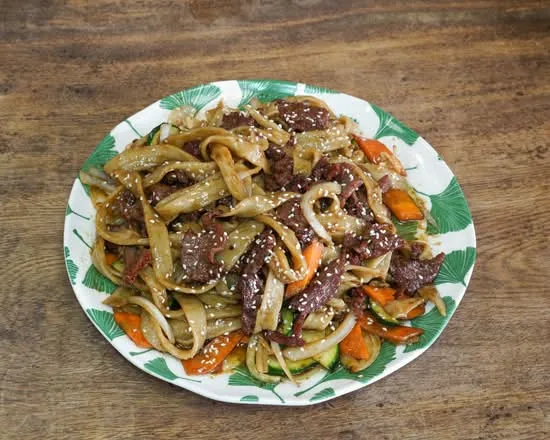 Des nouilles larges faites maison sautées au bœuf, avec courgette et carotte