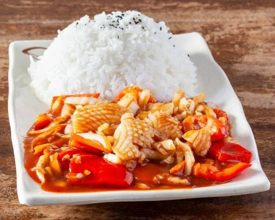 Un wok servi avec son bol de riz blanc offert