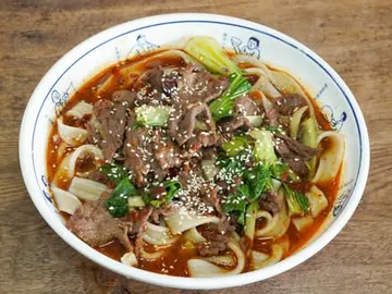 Bol de nouilles au bœuf dans un bouillon rouge pimenté